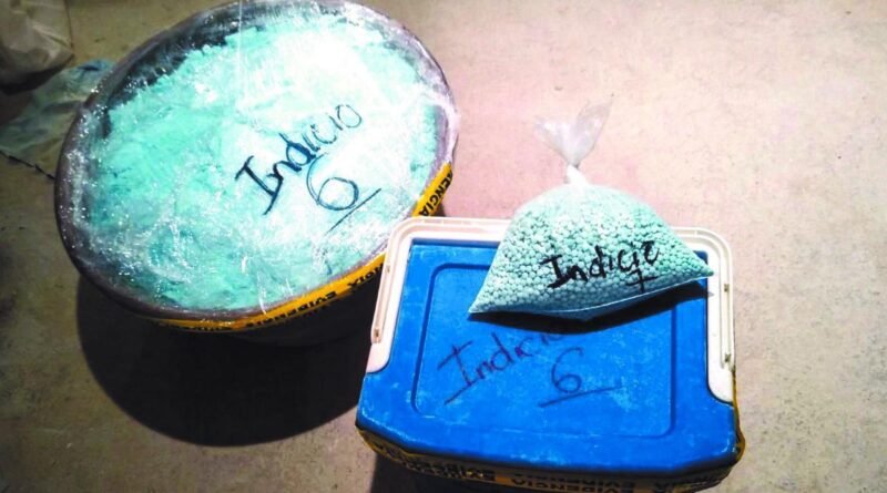 Recipiente grande, bolsa y caja azul con la inscripción «Indicio 6», fotografiados durante el registro de evidencias