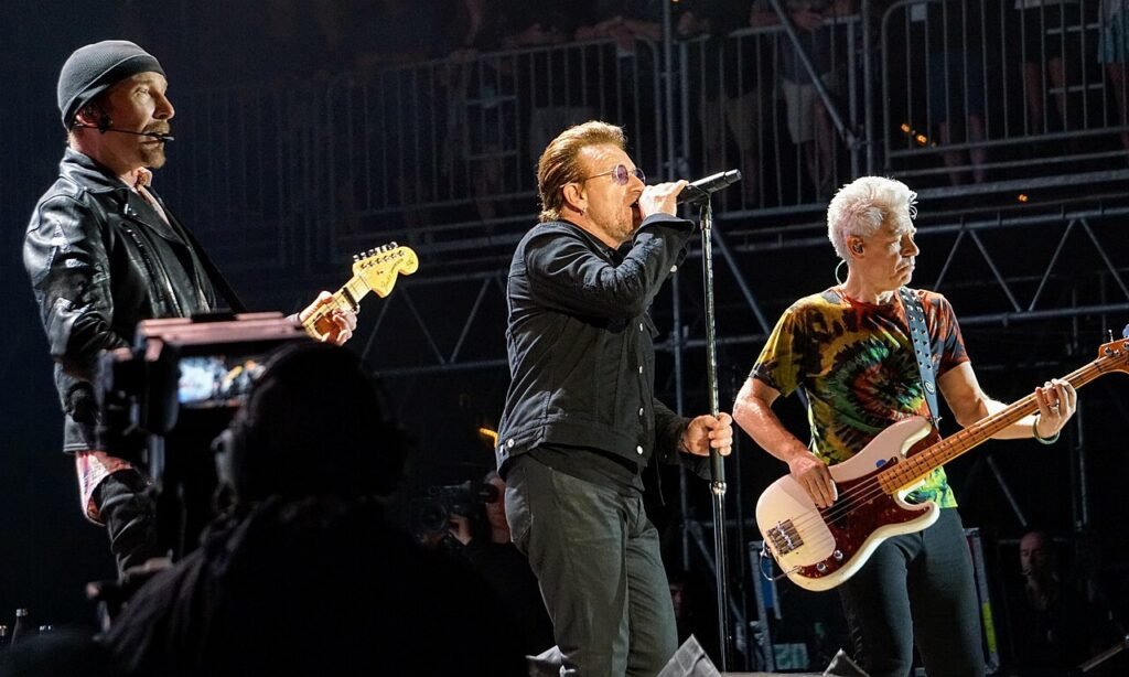 U2 durante un concierto de 2017, con The Edge, Bono y Adam Clayton en el escenario